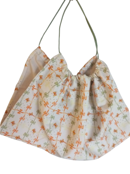 Weegdoek licht beige met oranjes groene strikjes en vlinders